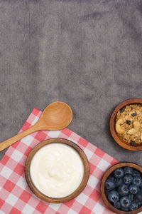 Healthy lifestyle concept, greek yogurt fresh blueberry and granola in bowl on red gingham cloth.