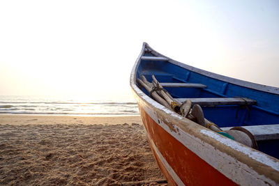 Boat moored on beach against sky