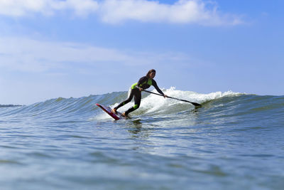 Female sup surfer on a wave