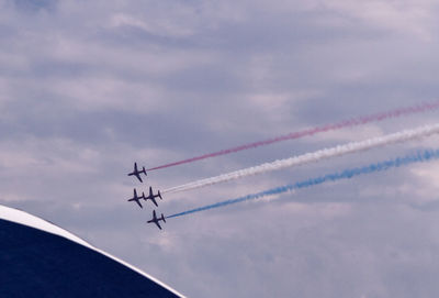 Low angle view of airplanes flying against sky