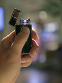 Close-up of hand holding illuminated cigarette lighter