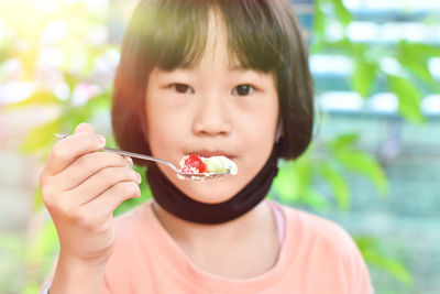 Close-up of child girl hands holding spoon eating ice cream. selective focus