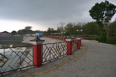 Footpath by street against sky in city