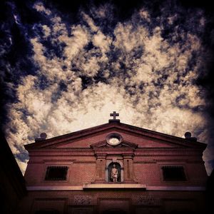 Low angle view of building against cloudy sky