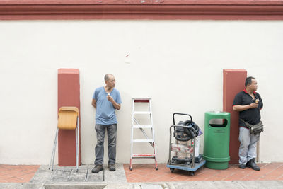 Young couple standing against wall