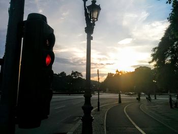 Road in city against sky during sunset