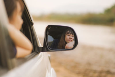 Reflection of woman on side-view mirror