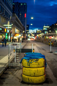Stacked tires on street in city at night