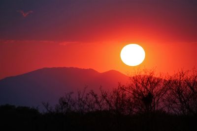 Scenic view of silhouette mountains against romantic sky at sunset