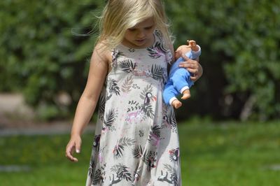 Girl carrying toy while walking on field