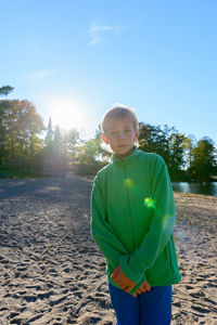 Full length of boy standing on land against sky