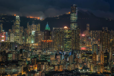 Illuminated cityscape against sky at night