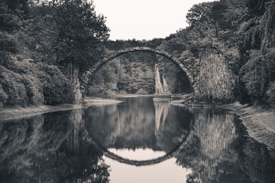 Arch bridge over lake against sky