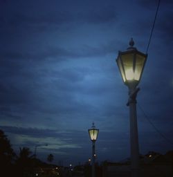 Low angle view of illuminated street light against sky