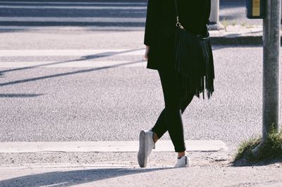 Low section of woman standing on road