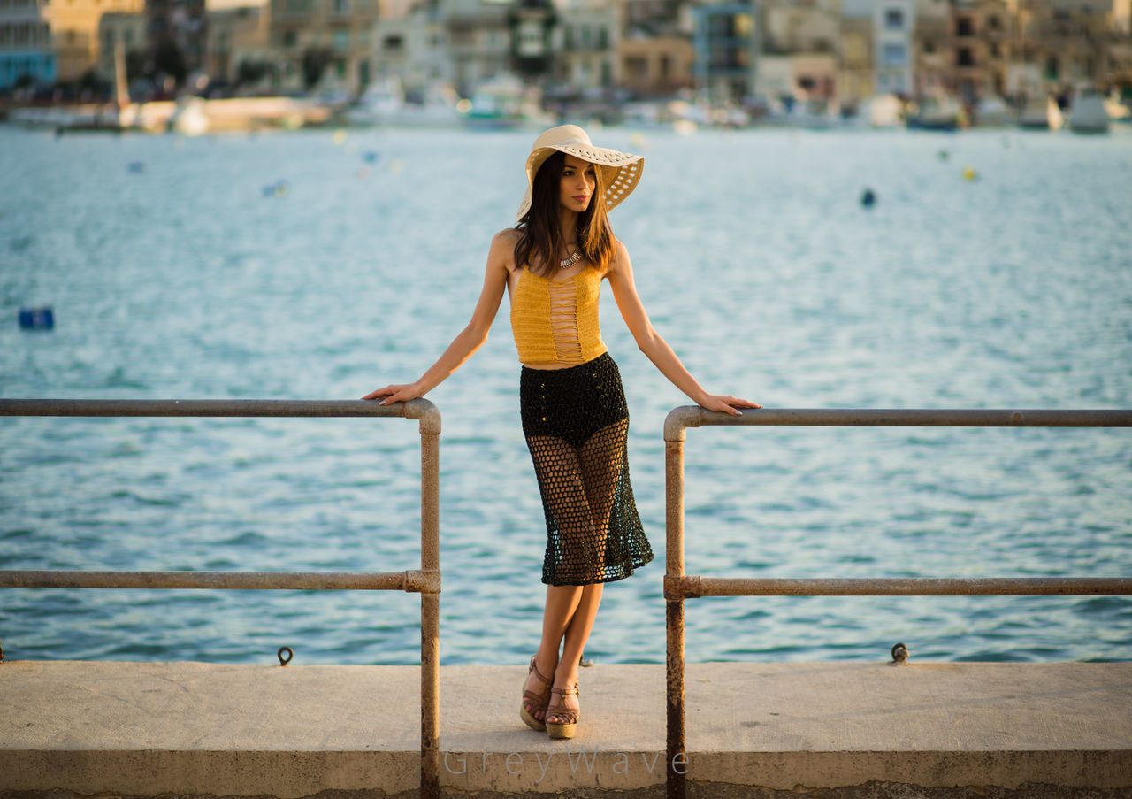 FULL LENGTH OF WOMAN STANDING BY SEA