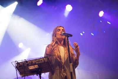 Low angle view of woman performing at music concert