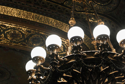 Low angle view of illuminated chandelier hanging in building