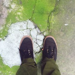 Human legs on concrete with cracks and moss