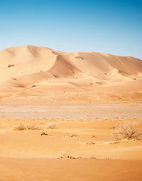 View of sand dunes in desert against clear sky