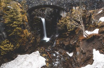 Waterfall at mount rainier seen through arch bridge