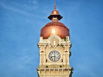 Low angle view of clock tower against blue sky