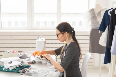 Side view of woman working in room