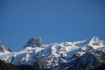 Scenic view of snowcapped mountains against clear blue sky