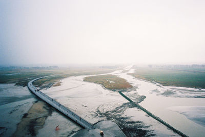 Scenic view of field against clear sky during winter