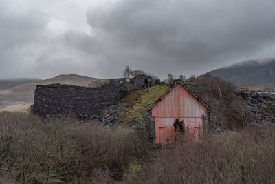 Abandoned building on field against sky