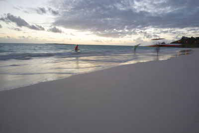 Scenic view of beach against cloudy sky