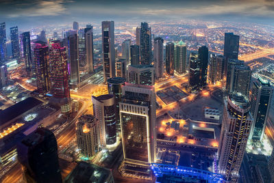 Aerial view of illuminated buildings in city at night