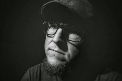 Close-up of thoughtful man over black background