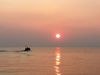 Silhouette of boat in sea during sunset