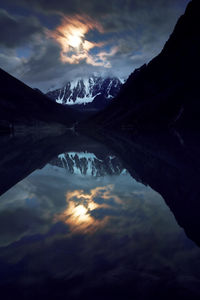 Scenic view of lake and mountains against sky during sunset