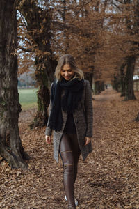 Smiling young woman walking during autumn