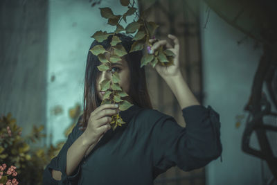 Portrait of woman holding plant