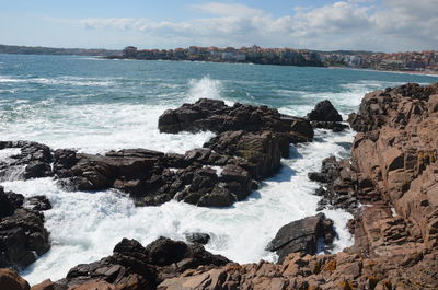 Scenic view of rocks in sea against sky