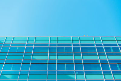 Low angle view of modern building against clear blue sky