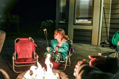 Rear view of woman sitting with umbrella