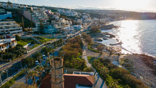 High angle view of townscape by sea against sky