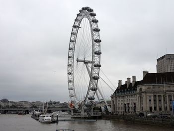 Ferris wheel in amusement park against sky