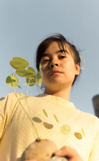 Low angle portrait of woman against plants