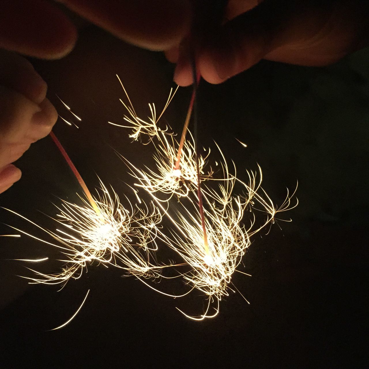 arts culture and entertainment, night, person, sparks, event, illuminated, firework display, leisure activity, motion, holding, firework - man made object, long exposure, celebration, lifestyles, unrecognizable person, exploding, sparkler