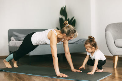 A young mother goes in for sports and makes a weight loss bar together with a small child at home.