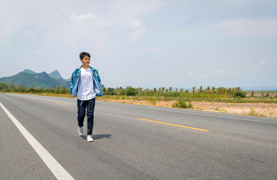 Full length of man standing on road against sky