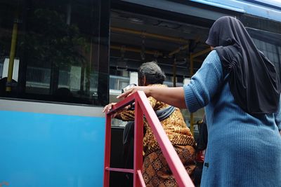 Rear view of women entering bus