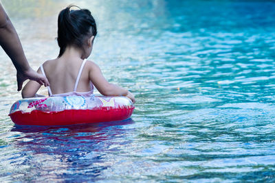 Girl with inflatable ring swimming in pool