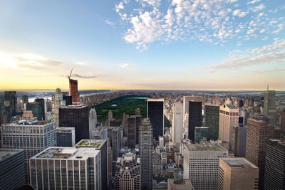 Modern buildings in city against sky during sunset