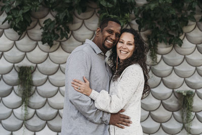 Portrait of married couple embracing and smiling outside